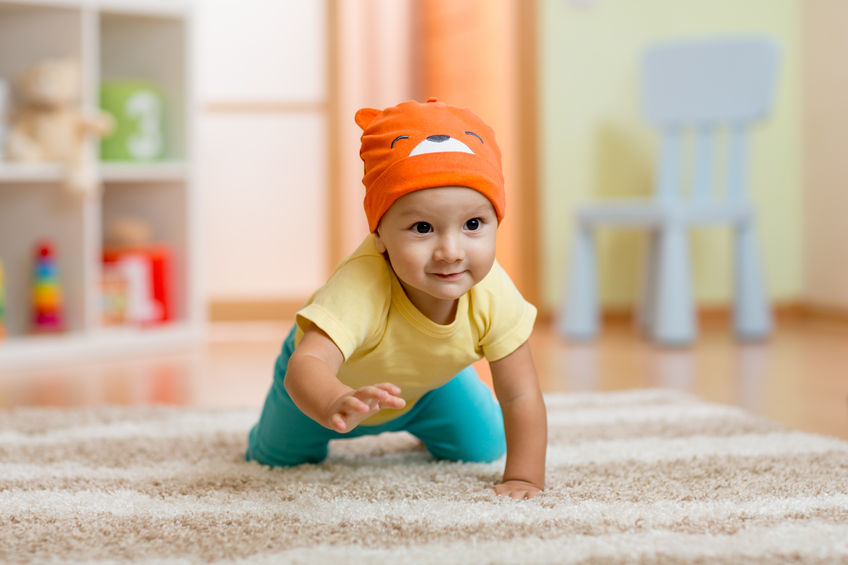 baby boy at home crawling on carpet